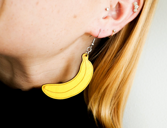 A person wearing wooden banana earrings